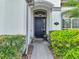 Charming front entrance with a dark door, stone pathway, and beautiful landscaping at 2891 Swoop Cir, Kissimmee, FL 34741