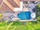 Aerial view showcasing a stunning pool, brick patio, outdoor seating, and lush greenery at 2891 Swoop Cir, Kissimmee, FL 34741