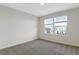 Bright bedroom with neutral walls and carpet, featuring two windows at 883 Griffon Ave, Lake Alfred, FL 33850
