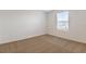 Well-lit bedroom with neutral walls and carpet at 883 Griffon Ave, Lake Alfred, FL 33850