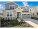 Two-story house with gray siding, stone accents, and a two-car garage at 883 Griffon Ave, Lake Alfred, FL 33850