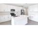 Modern kitchen with white cabinets, stainless steel appliances, and a large island at 883 Griffon Ave, Lake Alfred, FL 33850