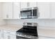 Stainless steel range and microwave in a modern kitchen setting at 883 Griffon Ave, Lake Alfred, FL 33850