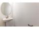 Modern powder room with pedestal sink and oval mirror at 883 Griffon Ave, Lake Alfred, FL 33850
