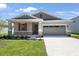 Charming single-Gathering home featuring a stone facade, red accents, a two-car garage, and a well-maintained front yard at 4220 Sawtooth Ct, Tavares, FL 32778