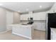Bright kitchen featuring white cabinets, stainless steel appliances, a large island, and light tile floors at 4220 Sawtooth Ct, Tavares, FL 32778