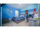 Blue accent bedroom with carpet, window, and a desk for a study or play area at 2378 White Lilly Dr, Kissimmee, FL 34747