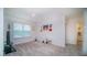Bright bonus room featuring neutral carpet, decor, and plenty of natural light from a large window at 2378 White Lilly Dr, Kissimmee, FL 34747