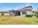 Landscaped backyard with covered patio and grassy lawn at 3875 Bowfin Trl, Kissimmee, FL 34746