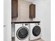 Laundry room with washer, dryer, and dark brown cabinets at 3875 Bowfin Trl, Kissimmee, FL 34746