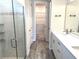 Bright bathroom features a glass shower, dual sinks, and quartz countertops plus a walk-in closet at 4520 Gliding Wave St, Winter Garden, FL 34787