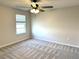 Bright bedroom with neutral paint, plush gray carpet, ceiling fan, and natural light from the window at 4520 Gliding Wave St, Winter Garden, FL 34787