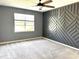 Bedroom featuring a unique accent wall, a ceiling fan, plush carpeting and bright window at 4520 Gliding Wave St, Winter Garden, FL 34787