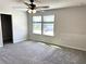 Bright bedroom with ceiling fan, neutral carpet, and a large window for natural light at 4520 Gliding Wave St, Winter Garden, FL 34787