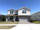 Charming two-story home with a gray stone accent wall and a well-manicured lawn on a sunny day at 4520 Gliding Wave St, Winter Garden, FL 34787