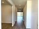 A well-lit hallway with wood-look tile flooring leads to a bright living space with sliding glass doors at 4520 Gliding Wave St, Winter Garden, FL 34787