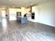 Open kitchen features white cabinets, an island with a sink, stainless steel appliances, and tile flooring at 4520 Gliding Wave St, Winter Garden, FL 34787