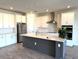 Modern kitchen with stainless steel appliances, white cabinets, stylish island, and beautiful tile flooring at 4520 Gliding Wave St, Winter Garden, FL 34787