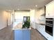 Open kitchen features white cabinets, an island with a sink, stainless steel appliances, and tile flooring at 4520 Gliding Wave St, Winter Garden, FL 34787