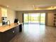 Modern kitchen featuring stainless appliances, island with sink, and tile floors with view to the patio at 4520 Gliding Wave St, Winter Garden, FL 34787