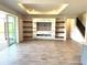 Bright living room features an entertainment center, floating shelves, tile flooring, and sliding glass doors at 4520 Gliding Wave St, Winter Garden, FL 34787