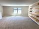 Spacious loft area with plush carpeting, built-in shelving, and natural light from double windows at 4520 Gliding Wave St, Winter Garden, FL 34787