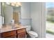 Bathroom features a marble countertop vanity, decorative mirror, and glass door access to shower at 14121 Bella Ln, Orlando, FL 32832