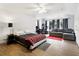Spacious bedroom has hardwood floors, sitting area with gray couch and red area rug, and office space at 14121 Bella Ln, Orlando, FL 32832