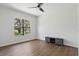 Bright bedroom with a ceiling fan, wood floors, a large window, and a TV stand at 14121 Bella Ln, Orlando, FL 32832