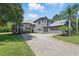 Stunning two-story home with a neutral color palette, mature landscaping, and a brick driveway at 14121 Bella Ln, Orlando, FL 32832
