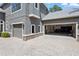 Attached three-car garage with paver driveway and stone accents on home at 14121 Bella Ln, Orlando, FL 32832