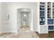 Hallway featuring tile floors, an arched doorway and a built-in shelving unit with cabinets at 14121 Bella Ln, Orlando, FL 32832