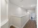 Bright hallway with hardwood floors and neutral paint, leading to bedrooms at 14121 Bella Ln, Orlando, FL 32832