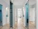 Bright hallway with mirrored closet doors and neutral tile flooring at 14121 Bella Ln, Orlando, FL 32832