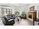 Bright living room with a fireplace, large windows, and comfortable leather seating at 14121 Bella Ln, Orlando, FL 32832