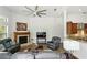 Cozy living room with a fireplace, comfortable seating, and a large ceiling fan at 14121 Bella Ln, Orlando, FL 32832