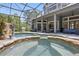 A screened-in pool, with waterfall and spa, surrounded by lounge areas at 14121 Bella Ln, Orlando, FL 32832
