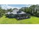 Back exterior featuring a screened enclosure, a backyard and solar panels at 14121 Bella Ln, Orlando, FL 32832
