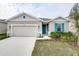 Curb appeal of a one-story house featuring gray siding and teal accents at 1634 Sugarbelle Cir, Mascotte, FL 34753