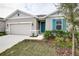 One-story house with gray siding, teal shutters, and a two-car garage at 1634 Sugarbelle Cir, Mascotte, FL 34753