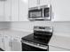 Stainless steel range and microwave installed above the counter at 1634 Sugarbelle Cir, Mascotte, FL 34753