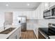 Modern kitchen with stainless steel appliances and white cabinetry at 1634 Sugarbelle Cir, Mascotte, FL 34753