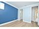 Bedroom with blue accent wall, hardwood floors, and a walk-in closet at 1862 Beach Ridge Rd, Celebration, FL 34747