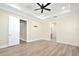 Spacious bedroom featuring tray ceilings, a fan, and light-colored hardwood floors at 1862 Beach Ridge Rd, Celebration, FL 34747