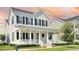 Inviting two-story home featuring a charming front porch with white columns and black shutters at 1862 Beach Ridge Rd, Celebration, FL 34747
