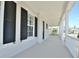 Inviting long front porch with white railings and columns, creating a welcoming outdoor space at 1862 Beach Ridge Rd, Celebration, FL 34747