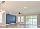 Spacious living room with hardwood floors, large windows, recessed lighting, and accent wall at 1862 Beach Ridge Rd, Celebration, FL 34747