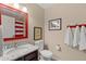 Bathroom with granite countertop, red and white striped shower curtain, and Mickey Mouse decor at 4552 Jonafree Ln # 106, Kissimmee, FL 34746