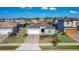 Aerial view of a single-Gathering home with a brick driveway, two-car garage, and well-maintained landscaping at 185 Brookes Pl, Haines City, FL 33844