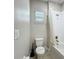Bathroom featuring a toilet, bathtub with shower, and a window with blinds for natural light at 185 Brookes Pl, Haines City, FL 33844